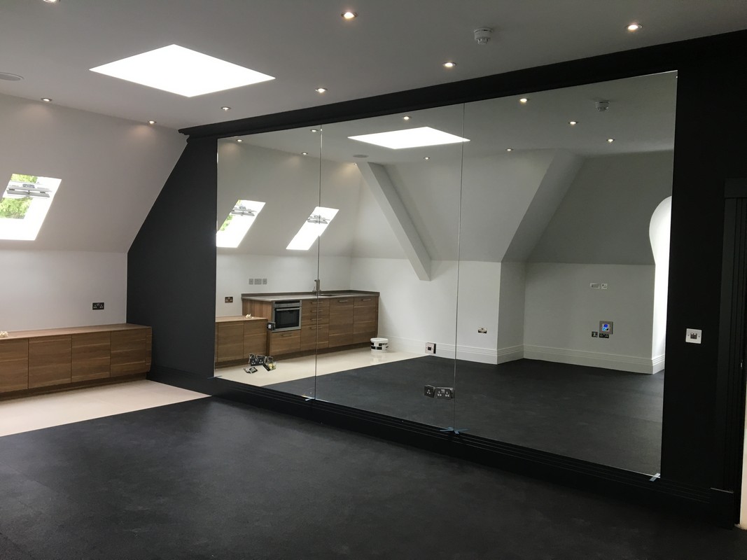 Frameless glass wall dividing loft conversion in Staines-upon-Thames